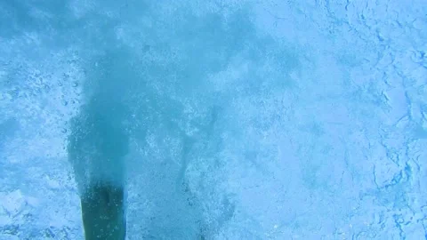 Bottom up view of feet slashing in the pool Stock Footage 134747201