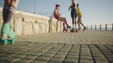 Bottom view of Four Friends rollerskating on the broadwalk and playing Stock Footage 279342075
