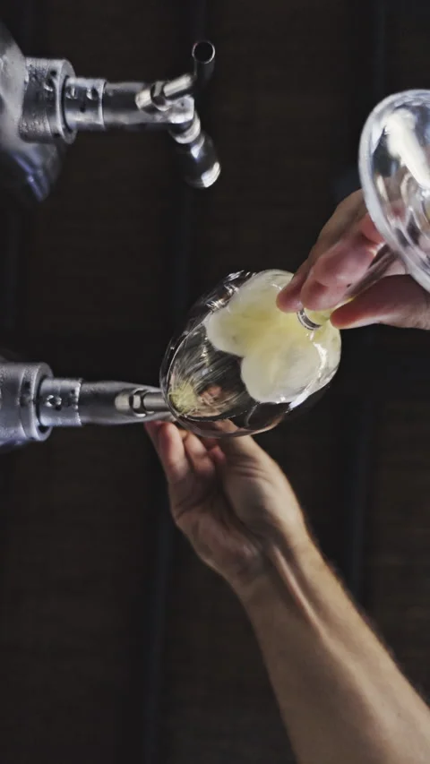 Bottom view of fresh draft beer pouring from a dispenser into a clear glass. Stock-Footage 342396230