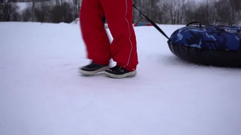 Bottom view. Girl pulls snow tubing, inflatable sled, winter sport Stock Footage 211626110