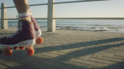 Bottom view of a girl rollerskating next to the ocean Stock Footage 279340237