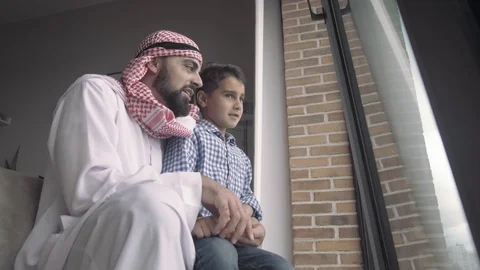 Bottom view handsome Arab man in traditional dress holds his son Video stock 113748846