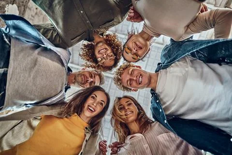 Bottom view of happy faces of diverse employees team standing in circle, look Stock Photos