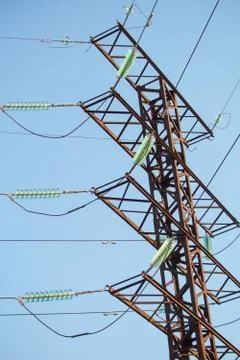 Bottom view on high voltage power lines against the blue cloudless sky Stock Photos