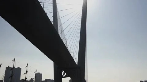 Bottom view of huge bridge in the sun against the background of urban new Stock Footage 134890698
