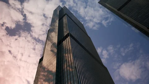 Bottom-up view of huge mirrored skyscraper against sunset sky. Business offices Stock Footage 243492842