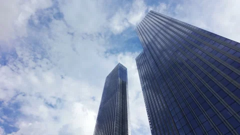 Bottom up view of large glass modern skyscrapers against a blue cloudy sky Stock Footage 276956426