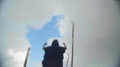 Bottom view of man in black robes standing on floating bamboo logs among fishing Stock Footage 220556786