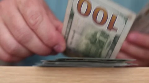 Bottom view. Man count paper American banknotes 100 USD on wood table Video stock 310902983