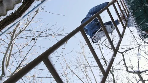 Bottom view of man rises to the attic on the iron stairs in the winter Stock Footage 73082667