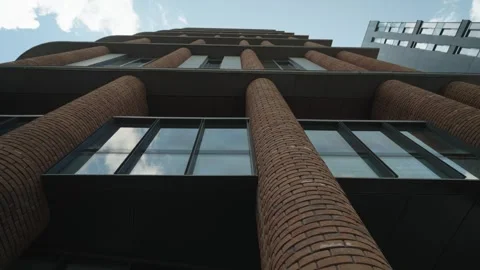 Bottom view of a modern brick building with mirrored windows Stock Footage 320889953