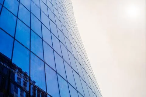 Bottom view of a modern skyscraper building with glass window against sky bac Stock Photos
