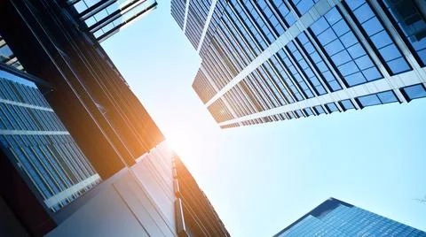 Bottom view of modern skyscrapers in business district against blue sky. Stock Photos