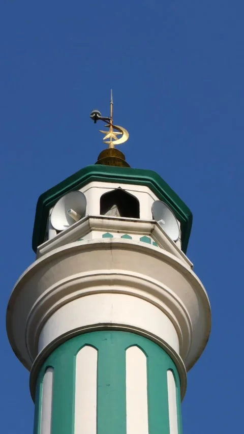 Bottom view of mosque minaret tower with crescent moon spire against clear .. Stock Footage 345198325