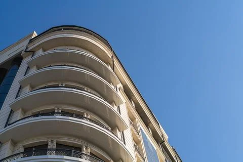 Bottom view of multi-storey building with round corner, panoramic balconies.. Stock Photos