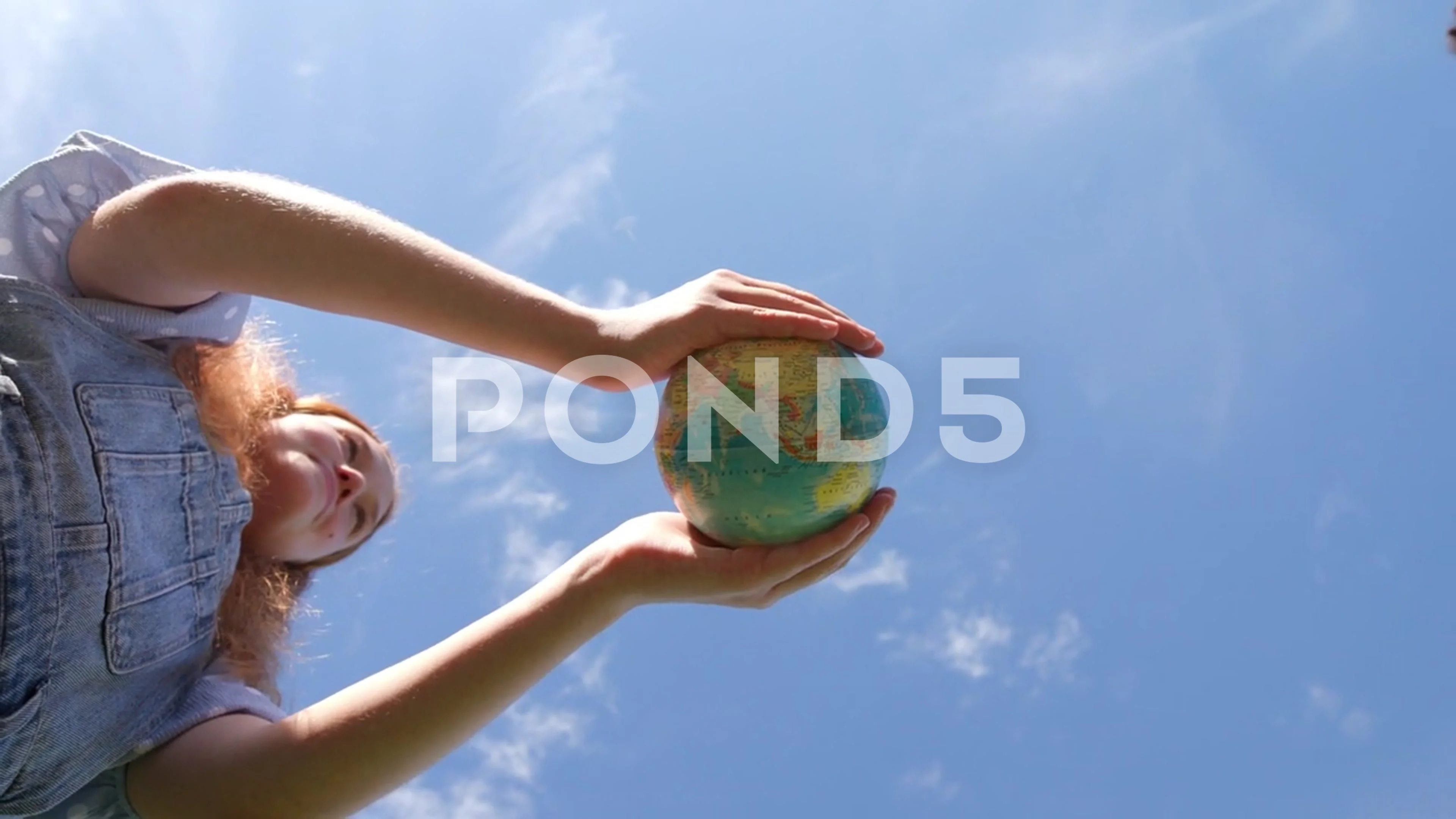 Bottom view of multiethnic teen students hold globe of the earth