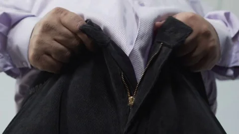 Bottom view of obese male trying to pull his pants zipper, mans health, closeup Stock Footage 84249802