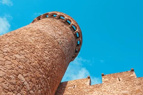 Bottom view of old medieval stone tower and wall in Tossa de Mar, Spain Stock Photos