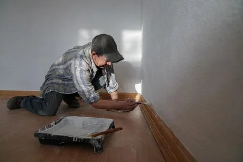 Bottom view of one painter man in shirt and black hat at work with a brush Stock Photos
