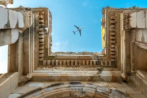 Bottom view of a passenger plane passing over the Celsus Library in the Anc.. Stock Photos