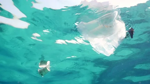 Bottom view of plastic debris drifts under surface of sea, slow motion Stock Footage 236194767