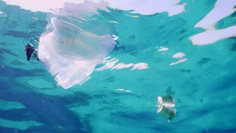 Bottom view of plastic debris drifts under surface of sea, slow motion Stock Footage 247400152