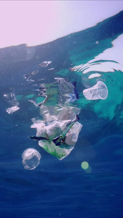 Bottom view of plastic debris drifts under surface of sea, slow motion Stock Footage 247400168