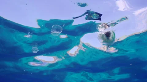 Bottom view of plastic debris drifts under surface of sea, slow motion Stock Footage 249395009