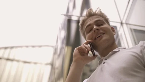 Bottom view a positive young stylish guy talking on a smartphone Stock Footage 114454388