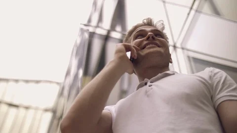 Bottom view positive young stylish guy talking on a smartphone Stock Footage 114454996