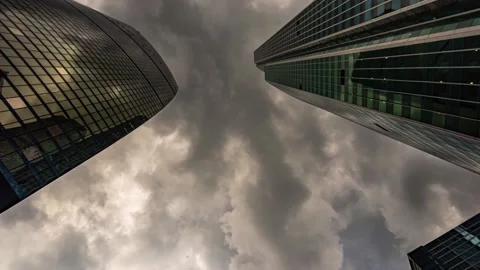 Bottom-up view of rotating skyscrapers and flying clouds, hyper lapse Stock Footage 155332055