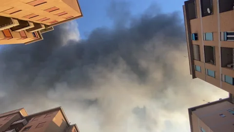 Bottom-up view shot of spreading toxic smoke above the buildings, smog emissions Stock Footage 203815344