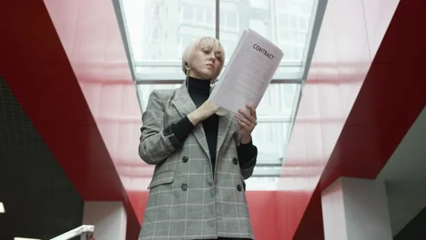 A bottom view slow motion close up shot of a blonde business woman standing in a Video stock 135874312