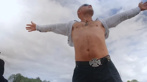 Bottom view of a standing man and spreading his arms against the background of Stock Footage 113279084