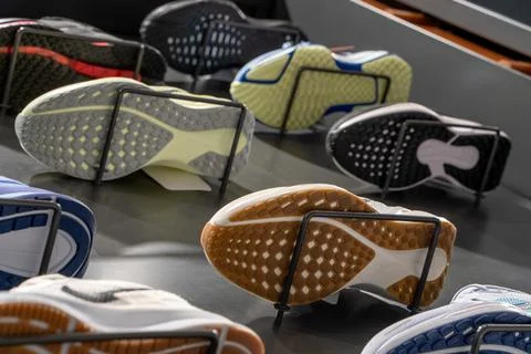 Bottom view of the store window with a modern new running shoes on the wall. Stock Photos