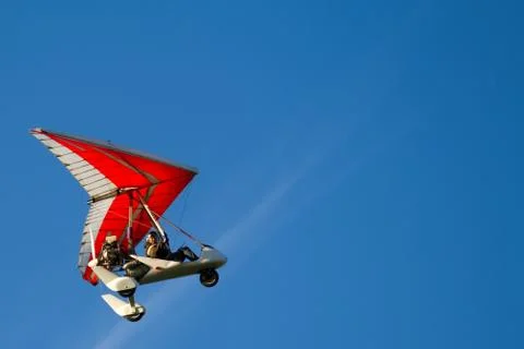 Bottom view super lightweight hang glider or trike flies in clear blue sky Stock Photos