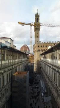 Bottom view of tall tower crane and ancient tower. An example of architectural Stock Photos