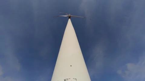 Bottom View of a Tall Wind Turbine Against Blue Sky Stock Footage 332042900