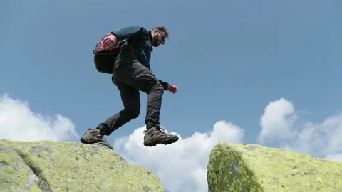 Bottom view of a tourist-climber walking along the rocky mountains. Stock Footage 247663687