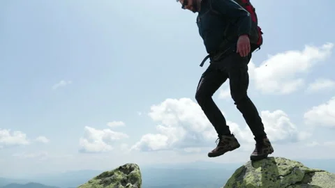 Bottom view of a tourist-climber walking along the rocky mountains. Stock Footage 247663723