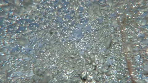 Bottom view of tumultuous current of many air bubbles sparkling under water Stock Footage 311568079