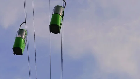 Bottom view two green cabins move by cable way Stock Footage 95769870