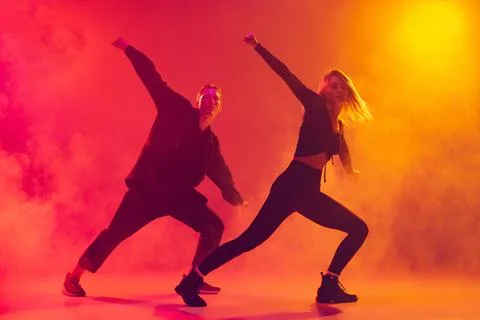 Bottom view of two young hip-hop dancers in motion isolated over gradient pink Stock Photos