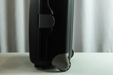 Bottom view of upright suitcase on white fabric backdrop, close-up travel g.. Stock Photos