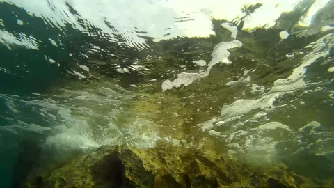 Bottom up view video of medium waves hitting shoreline rocks in Croatia Stock Footage 292450103