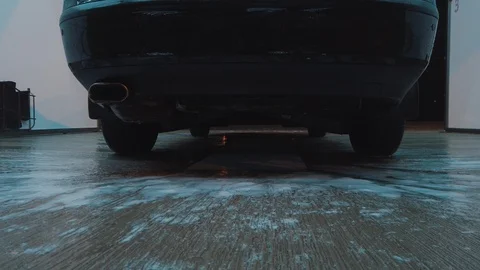 Bottom view of water droplets and soap sucking down the bumper of a black car. Stock-Footage 121854047