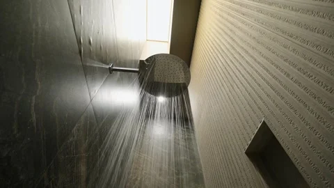 Bottom view of water running from round silver shower head in stylish interior Stock Footage 259715019