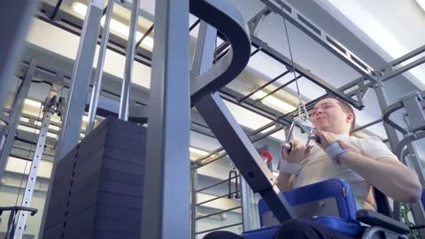 Bottom view of weights being lifted by an invalid in a wheelchair Stock Footage 87608382