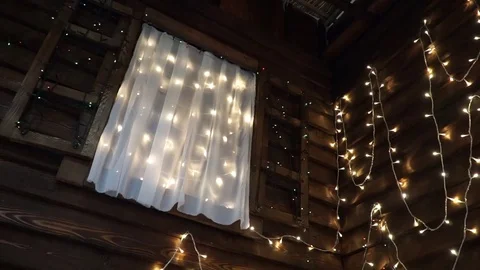 Bottom view on the window with shimmering garlands in a wooden house Stock Footage 71027969