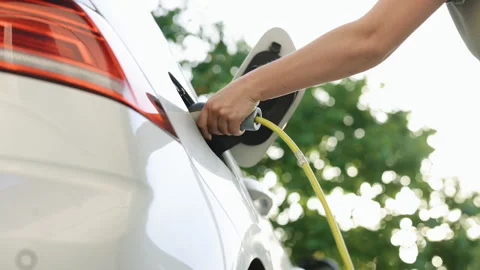 Bottom view of woman hand inserts power cable supply to charge electric or EV Stock Footage 200831648